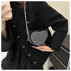 Detailed view of shimmering heart-shaped rhinestone handbag with silver metal chain strap