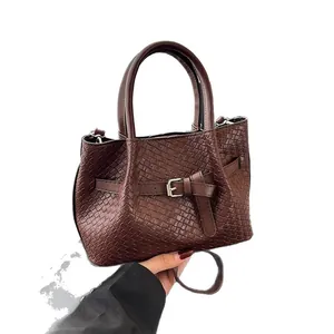 Brown woven leather bucket bag with top handles and adjustable shoulder strap