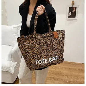 Detail view of large leopard print canvas tote bag with white TOTE BAG lettering print