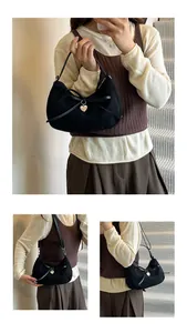Détail du sac hobo noir avec texture en daim et pendentif en forme de cœur doré