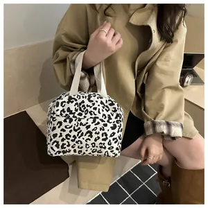 Detail of leopard print tote bag featuring corduroy texture and cream webbing handles