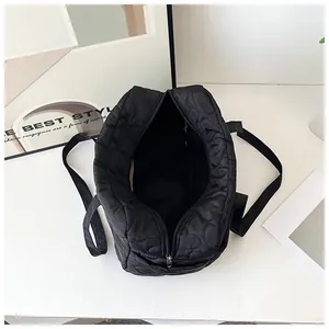 Vue de dessus d'un grand sac matelassé noir à motifs de cœurs avec ouverture zippée intérieure