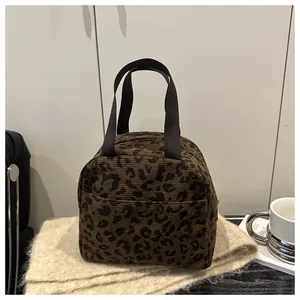 Detail of leopard print corduroy lunch bag featuring soft texture and sturdy handles