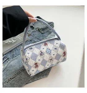 Détail de la trousse de maquillage à carreaux bleus avec tissu matelassé et motif ours