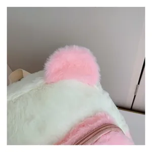 Close-up of pink faux fur ears and zipper detail on a soft winter plush backpack
