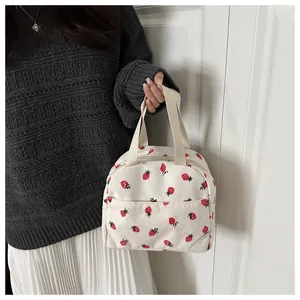 Close-up of strawberry print corduroy lunch bag with wide handles and zipper closure