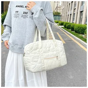 Détail du sac cabas matelassé blanc avec broderie cœur et poche zippée à l'avant