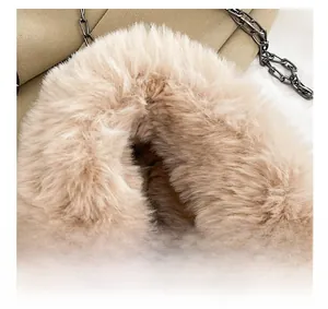 Detailed close-up of soft plush handle and dark metal chain strap on fluffy handbag