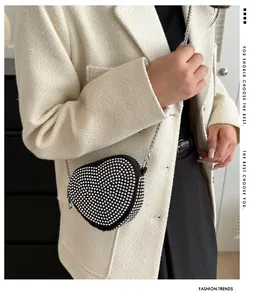 Close-up of sparkling rhinestone heart-shaped crossbody bag with silver chain strap