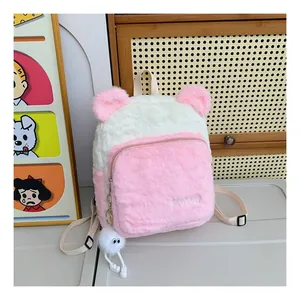 Detail of plush pink and white backpack with cute fuzzy ears and a soft hanging charm