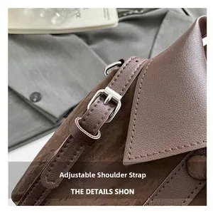 Detail of adjustable leather strap with silver buckle on a dark brown crossbody bag