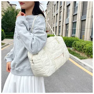 Détail du sac bandoulière blanc cassé avec matelassage en cœur et poche zippée