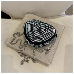 Macro detail of heart-shaped handbag with iridescent rhinestones and silver chain