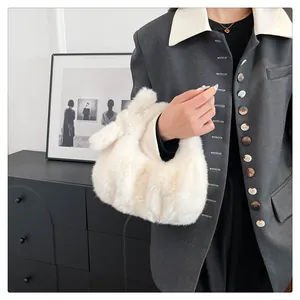 Detail van een zachte witte pluche handtas gestyled met een grijze blazer outfit