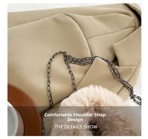 Detail of beige faux fur trim and dark metal chain strap on a plush winter crossbody bag