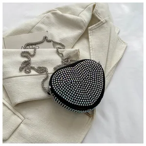 Detailed view of black heart-shaped handbag with multi-color rhinestones and silver chain