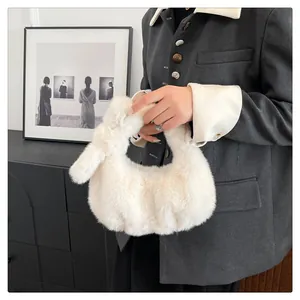 Detailopname van een crème-witte pluche handtas van imitatiebont met geknoopte handgreep