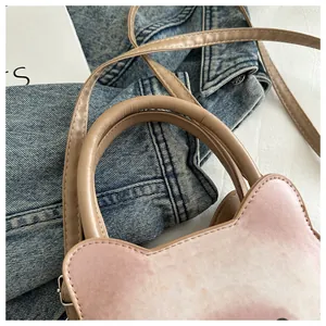 Détail du sac à bandoulière en dégradé avec oreilles de chat et poignée cylindrique