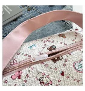Gros plan sur la texture du sac matelassé avec oursons et détails de poignée rose
