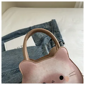 Détail du sac à main chat dégradé rose avec traits du visage mignons et anses arrondies