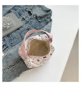 Gros plan d'un sac à main matelassé aux motifs sucrés avec poignée rose et intérieur vaste