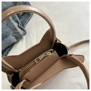 Vue de dessus du compartiment intérieur avec poche zippée d'un sac bandoulière en similicuir