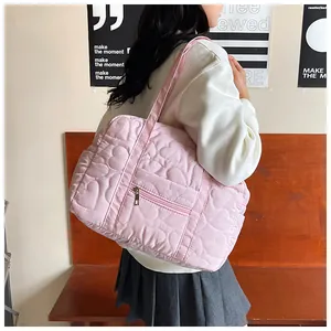 Détail du sac cabas rose matelassé avec motifs de cœur et poche zippée avant fonctionnelle