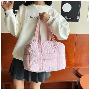 Détail du cabas matelassé rose avec broderie en cœur et poche à fermeture éclair en métal