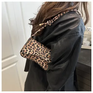Close-up of leopard print shoulder bag featuring a flap closure and gold metal accents