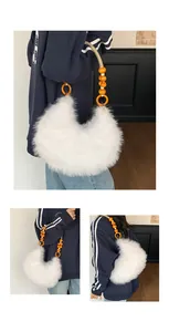 Detail of white faux fur shoulder bag featuring vibrant orange beaded handle and crescent shape