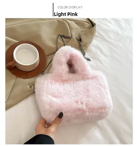 Detailed view of light pink plush handbag with dark metal chain strap in lifestyle setting