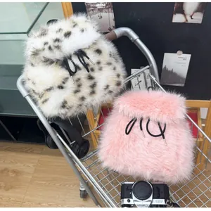 Close-up of leopard print and pink faux fur plush backpacks with drawstring closure