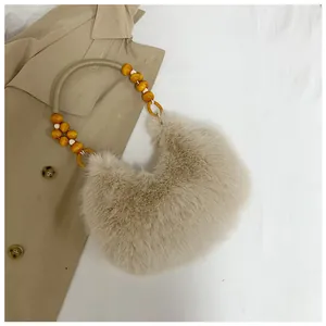 Detail of faux fur shoulder bag with decorative woven rope and wooden bead handle