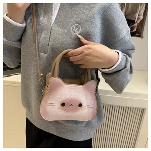 Détail du sac bandoulière en forme de chat avec motif imprimé et anses marron