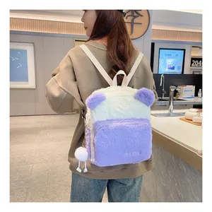 Detail view of plush purple and white cartoon backpack with cute animal ears and pompom charm