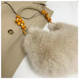 Detailed close-up of faux fur handbag with golden beaded handle on a khaki trench coat