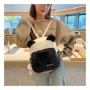 Detailed close-up of a plush panda backpack with soft fur and decorative bear pendant