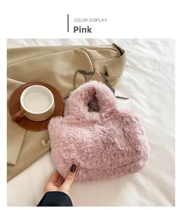 Detail of a purple pink fuzzy plush crossbody bag with a metallic chain strap on a blazer