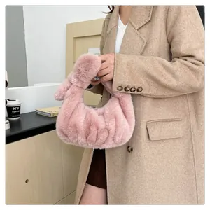 Detail van een roze geplooide tas van imitatiebont met een geknoopte handgreep voor de herfst