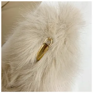 Close-up of soft beige faux fur texture with a polished gold metal rectangular buckle