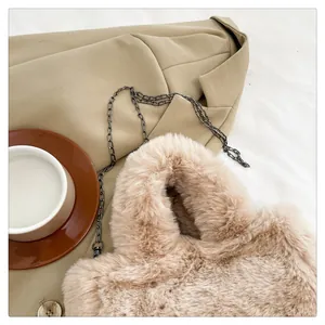 Detailed texture of plush faux fur crossbody bag with sleek metal chain strap on blazer