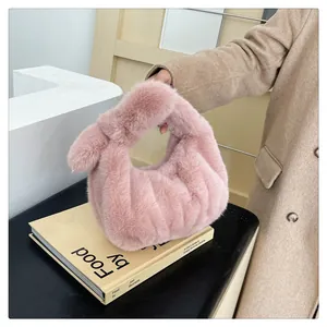 Detail van roze pluche handtas met zachte geplooide textuur en geknoopt handvat