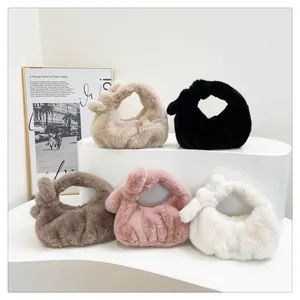 Detail van pluche handtassen in vijf kleuren met gedraaide handvatten op een display