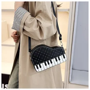Detailweergave van creatieve tas in de vorm van een piano met zwart-witte toetsen en stippen