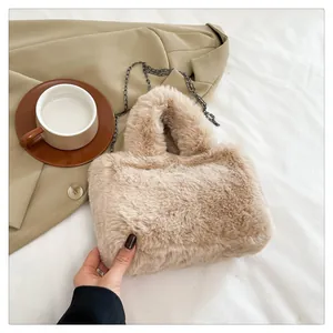 Close-up of plush beige handbag with soft faux fur texture and elegant chain strap detail