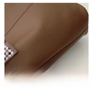 Detailed macro view of the brown pebble grain leather tote with checkered scarf detail