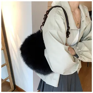Detail of black plush faux fur handbag featuring a unique dark brown wooden beaded strap