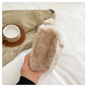 Detail of plush faux rabbit fur handbag in beige with dark metal chain strap