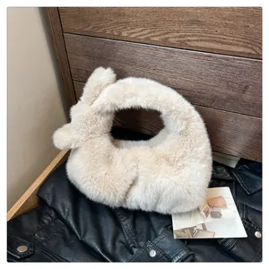 Detailopname van een zachte crème faux fur handtas met knoophendel op leren ondergrond
