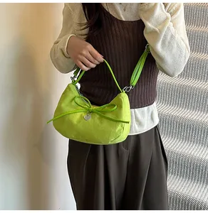 Détail du sac cabas en daim vert citron avec décoration nœud et pendentif en cœur